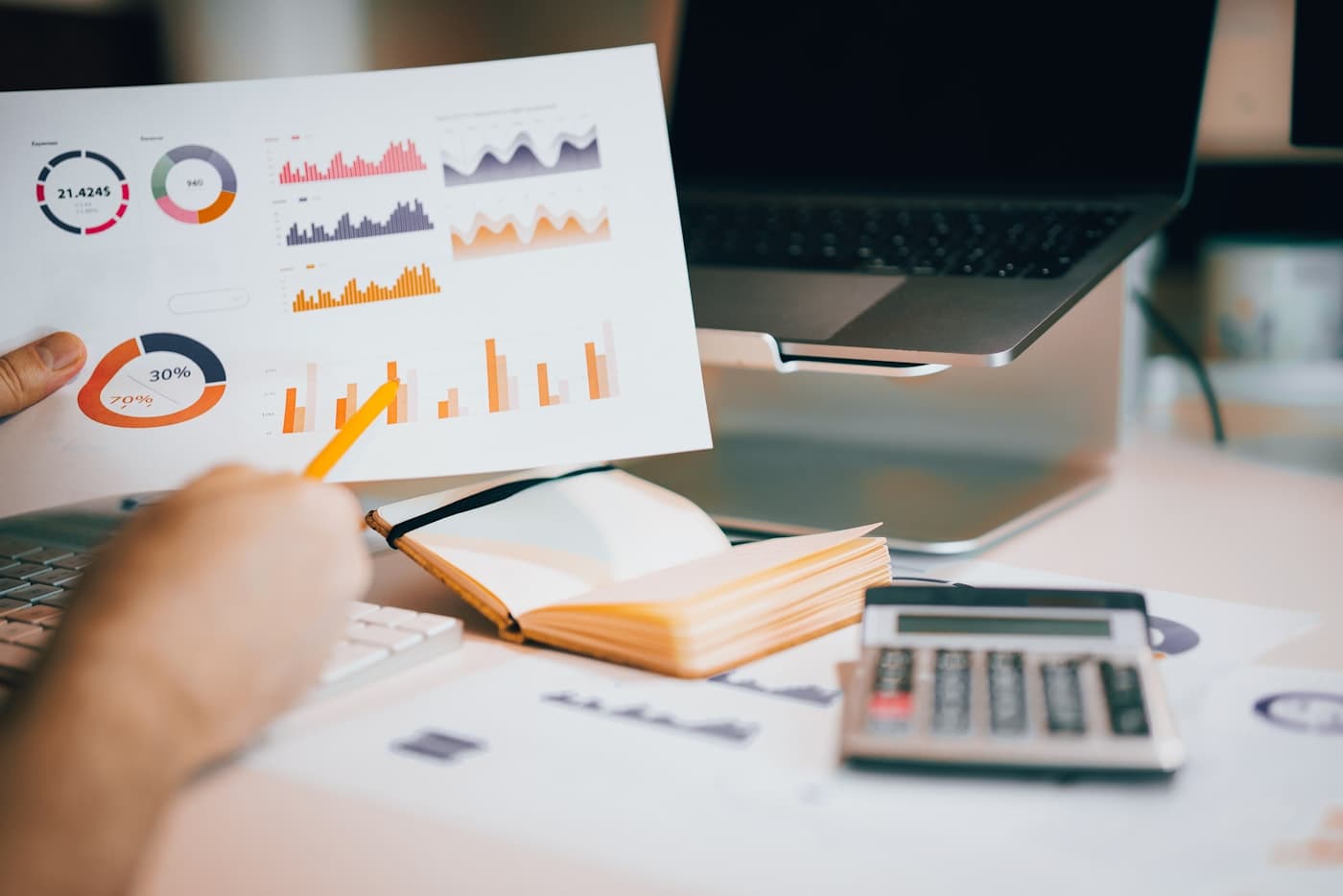 Reviewing a financial report with charts, laptop, and calculator